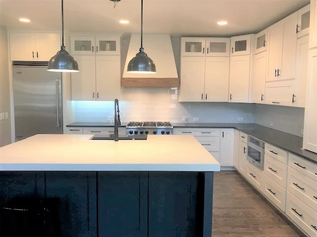 Modern Arvada kitchen with new white cabinets and dark island featuring wood pullout organizers for efficient storage