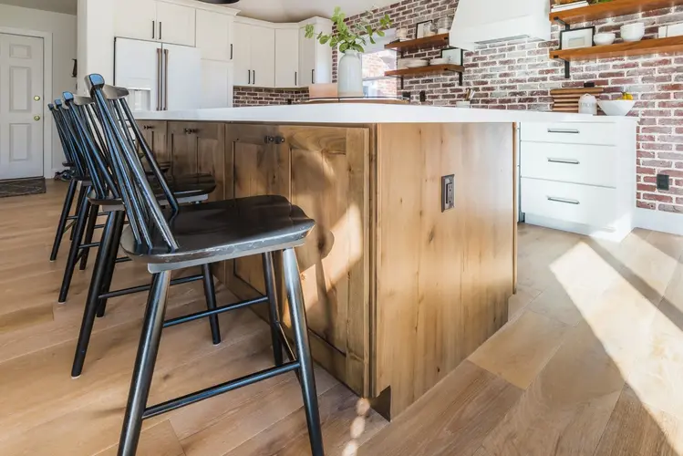 Sleek wooden kitchen cabinets and matching chairs after a kitchen cabinet replacement in a modern Broomfield home