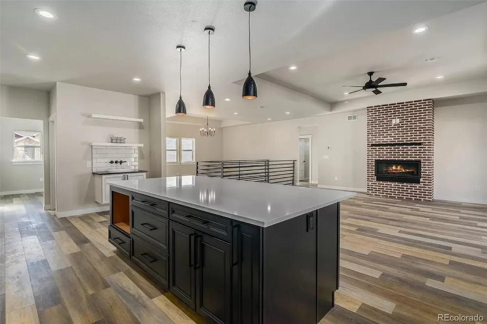 Modern open-concept kitchen remodel in Denver with large black island and quartz countertops