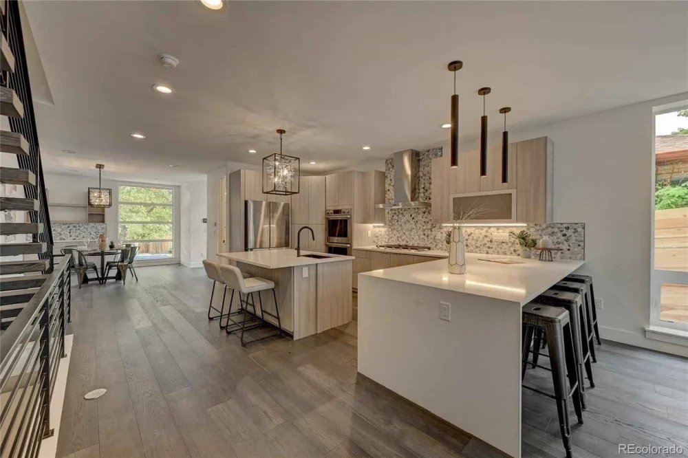 Spacious kitchen with two-tone cabinetry, large island, and elegant lighting fixtures