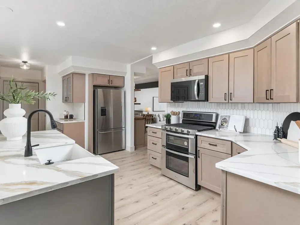 Bright remodeled kitchen with stainless steel appliances and beige cabinetry